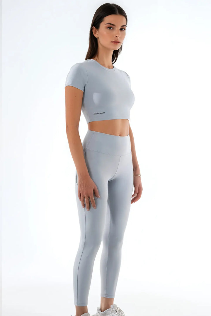 Açık gri kadın spor crop top ve yüksek bel sporcu taytı sağ ön çapraz uzak açı Promise Athletic